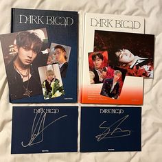 three books with autographs on them sitting on a bed