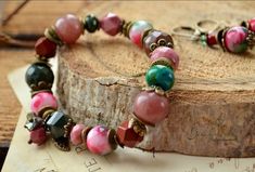 Bright color gemstone bracelet. Made from large natural beads of jade, faceted pink rhodonite, strawberry quartz, chrysocolla, mookaite and faceted Indian agate. Decorated with a miniature Czech glass pendant and antique bronze colored fittings.  The bracelet is available in 7 sizes, depending on the size of the wrist: Wrist - 14-14.5 Centimeters (5.51-5.70 inch). Wrist - 15-15.5 Centimeters (5.90-6.10 inch). Wrist - 16-16.5 Centimeters (6.29-6.49 inch). Wrist - 17-17.5 Centimeters (6.69-6.88 in Pink Bohemian Bracelets With Faceted Beads, Pink Agate Beaded Bracelets With Natural Stones, Vintage Pink Bracelets With Round Beads, Handmade Pink Agate Bracelets, Multi Colored Jade Bracelet, Bohemian Pink Agate Bracelets, Pink Agate Round Bead Crystal Bracelet, Hand-strung Round Rose Quartz Bracelets, Hand-strung Jade Crystal Bracelet