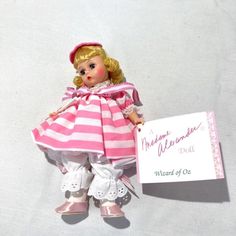 a doll holding a sign that says welcome to me and my mom on the front