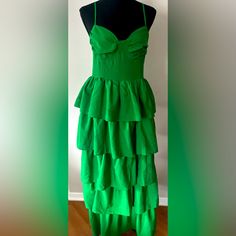 a green dress is displayed on a mannequin