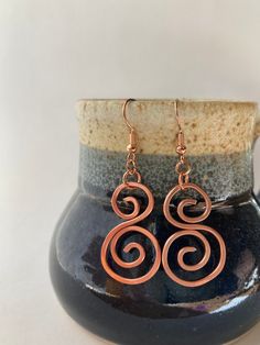 Introducing our Handcrafted Copper Double Spiral Earrings! Meticulously crafted, these stunning earrings showcase a captivating double spiral design. Each pair is lovingly handmade, ensuring a unique touch to every piece. Radiant and conversation-starting, they're the perfect accessory to elevate any outfit, whether it's for work or play. Stand out with style and charm wherever you go! Handmade Spiral Earrings As Gift, Adjustable Spiral Earrings For Gifts, Handmade Swirl Earrings As Gift, Handmade Swirl Earrings For Gifts, Unique Handmade Spiral Earrings, Handmade Spiral Wrap Earrings Gift, Handmade Metal Swirl Earrings, Handmade Swirl Metal Earrings, Spiral Copper Wire Earrings As Gift