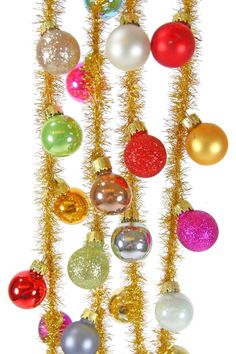 an assortment of christmas ornaments hanging from gold tinsel