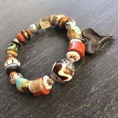 "Boho at its best!   This bracelet is perfect to wear with your Fall neutrals.. cream sweater and jeans, leather boots, a great dress as the weather gets cooler and into the holidays..  It is designed around a gorgeous Nepali Silver capped Horn bead from Tibet.  This is combined with a rustic eclectic Fall mix of beads and stones including Ostrich Shell, Red Jasper, Genuine Hubei Turquoise, carved bone beads, faceted Citrine and a silver rimmed ebony wheel.  An artisan blackened bronze rustic he Bohemian Bracelets With Large Beads For Healing, Bohemian Healing Bracelets With Large Beads, Southwestern Natural Stones Beaded Bracelet Gift, Bohemian Crystal Bracelet With Large Beads For Gift, Southwestern Natural Stones Beaded Bracelets For Festivals, Southwestern Natural Stone Beaded Bracelets For Festivals, Handmade Southwestern Healing Bracelets, Southwestern Gemstone Beaded Bracelets For Healing, Southwestern Style Hand-strung Bracelet Gift