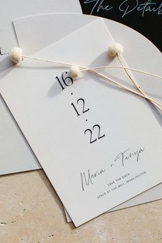 the wedding stationery is laid out on top of two envelopes and tied together with twine