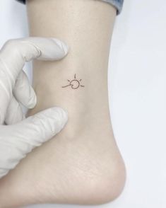 a person is getting a small tattoo on their foot