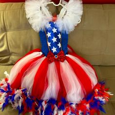 a red, white and blue dress is sitting on a couch