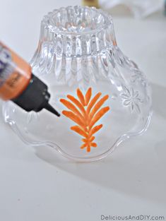 an orange and black marker is next to a clear glass vase