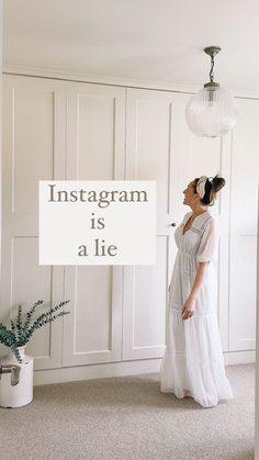 a woman standing in front of a white wall with the words instagram is a lie on it