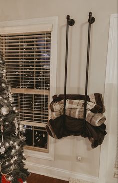 a small christmas tree in the corner of a room with a window and shutters