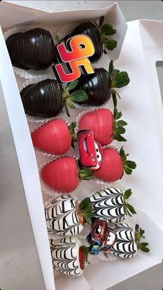 some chocolate covered strawberries in a box with the letters h on them and other decorations