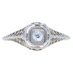 Size: 6 Sizing Fee: Up 2 sizes for $35 or Down 1 size for $35 Era: Art Deco Date: 1920s - 1930s Metal Content: 18k White Gold Stone Information Natural Diamond Carat(s): .10ct Cut: European Color: G Clarity: VS2 Total Carats: .10ct Style: Solitaire Features: Floral Filigree & Milgrain Detailing Measurements Face Height (north to south): 5/16" (7.8mm) Rise Above Finger: 1/4" (5.6mm) Weight: 1.5 Grams Stamps: 18k Condition: Pre-Owned Professionally cleaned, polished, and tested to guarantee metal Floral Filigree, Rise Above, La Face, Gold Stone, Jewelry Rings Engagement, Diamond Art, Solitaire Engagement, Solitaire Engagement Ring, White Gold Diamonds