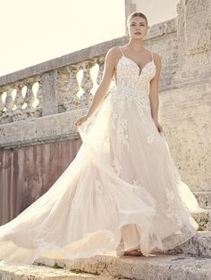 a woman in a wedding dress standing on some steps