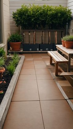 an outdoor patio with benches and potted plants on the side of the house,