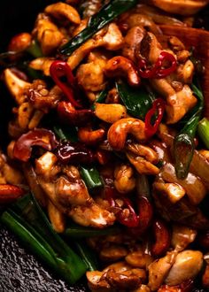 stir fry with chicken, green beans and peppers in a black bowl on top of a table