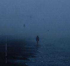 people walking on the beach in the fog