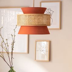 a green vase sitting on top of a wooden table next to pictures and a lamp