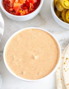 there is a bowl of salsa next to some pita bread and other food items