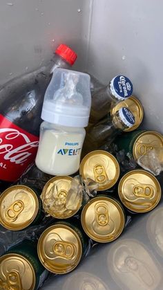 an assortment of sodas and soft drinks in plastic containers, with one empty bottle on top