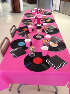 a pink table with black and white plates on it