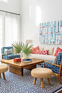 a living room filled with furniture and a large painting on the wall above it's coffee table