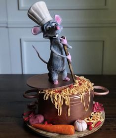 a cake shaped like a mouse with a chef's hat on top of it