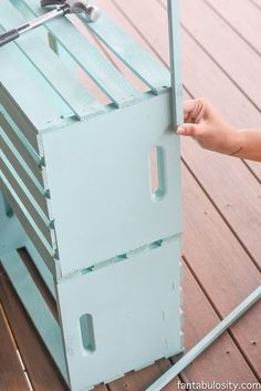 a person is holding the door to a blue crate