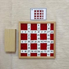 a red and white board with numbers on it next to a wooden block that is attached to the wall