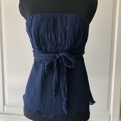 This Blue, Silk, Strapless Empire Waist Blouse With Straight Across Neckline Has 52” Wrap Belts Attach On Each Made To Be Wrap Twice And Then Tie Into A Simple Knot Of Bow Either At The Front Or Back Of The Waistline. New, Never Worn Because Runs Smaller Than The Medium Size. It’s Best Fitted For Extra Small. Chic Blue Tube Top For Evening, Elegant Fitted Blue Tube Top, Elegant Blue Tube Top For Summer, Elegant Blue Sleeveless Tube Top, Elegant Blue Tube Top For Party, Elegant Blue Strapless Tube Top, Blue Strapless Tops For Summer, Strapless Blue Beach Top, Blue Strapless Beach Top