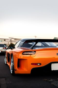 an orange sports car parked in a parking lot