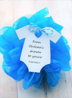 a blue mesh ball with a baby's shirt on it and a tag that says from chelsea's shower to yours