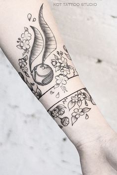 a woman's arm with a tattoo on it and a vase in the middle