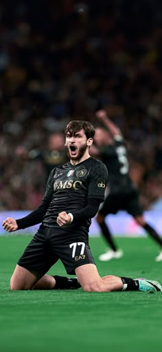 a soccer player sitting on the ground with his mouth open