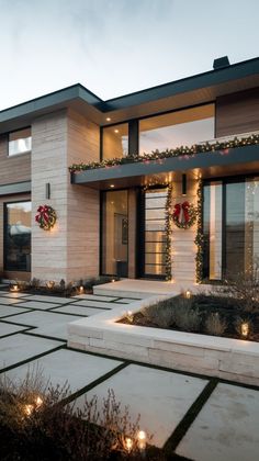 a modern house decorated for christmas with wreaths and lights