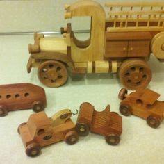 wooden toy cars and trucks are on the floor next to each other, with one car missing