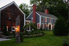 a large house sitting next to a lush green field