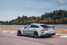 a grey sports car driving on a race track