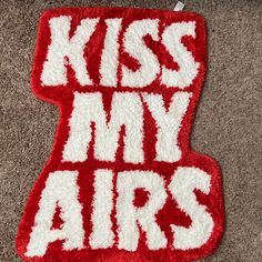 a red and white rug with the words kiss my airs written in large letters on it