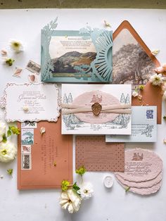 the wedding stationery is laid out on top of each other, including envelopes and cards