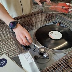 a person with a watch on their wrist is playing the record player's turntable