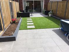 a backyard with grass and stepping stones in the middle