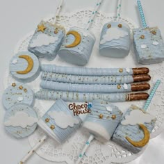 baby shower items are arranged on a white doily with blue and gold trimmings