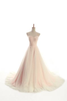 a pink dress on a mannequinl stand in front of a white background