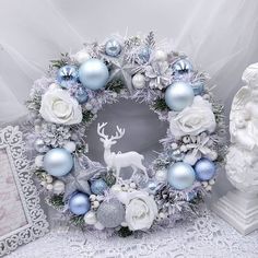 a white and blue christmas wreath surrounded by ornaments