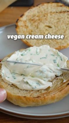 a person is spreading cream on top of a piece of bread with the words vegan cream cheese over it