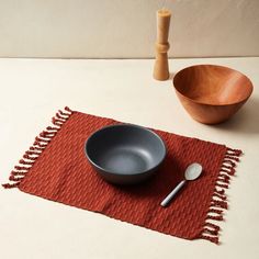 a bowl and spoon sitting on a place mat