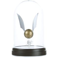 a glass dome with a gold ball inside it and wings on the top, in front of a white background