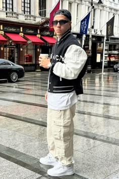 a man standing on the street holding a coffee cup