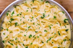 a pan filled with pasta and sauce on top of a wooden table