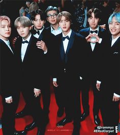 a group of young men in tuxedos posing for a photo on the red carpet