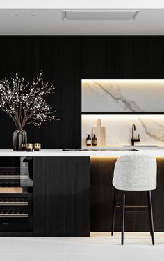 a modern kitchen with marble counter tops and black cabinets, along with a white bar stool